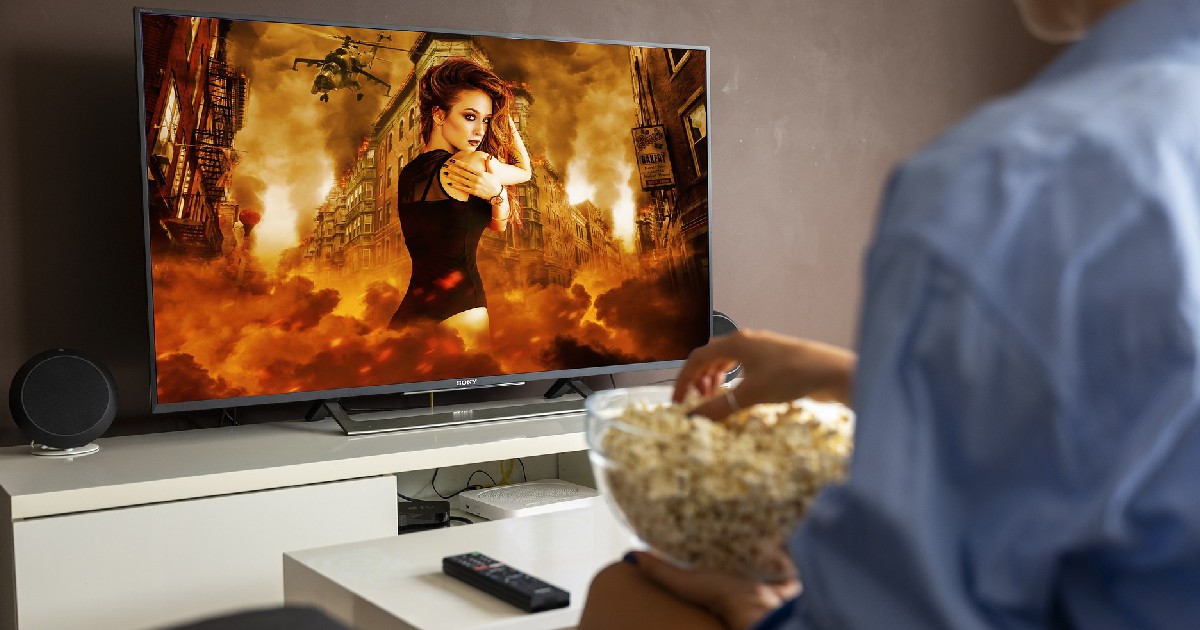 persona che mangia popocorn davanti a una serie tv